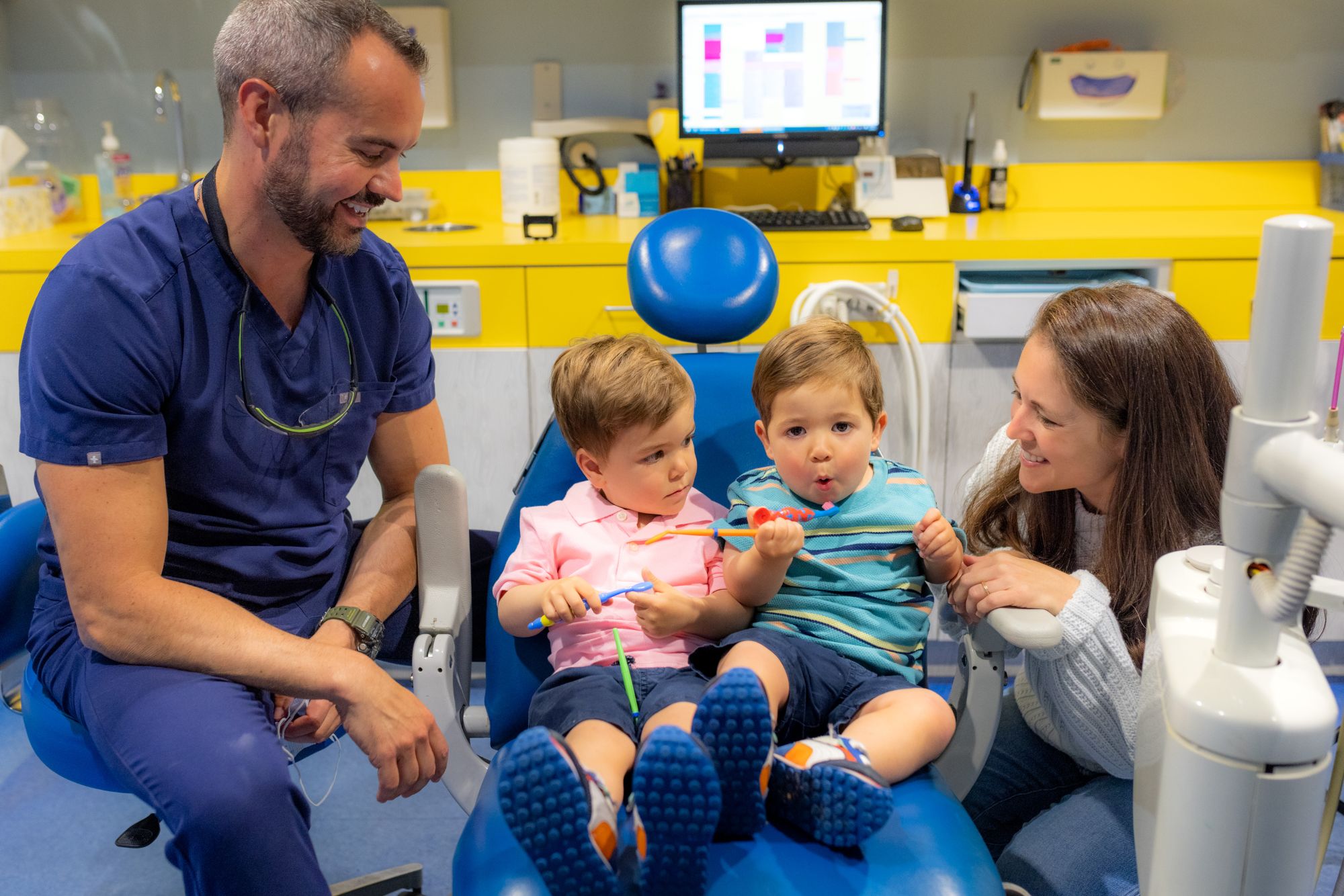 A Smiling Toddler Learning What To Expect During Their First Pediatric Dentist Visit At Cobblestone Kids